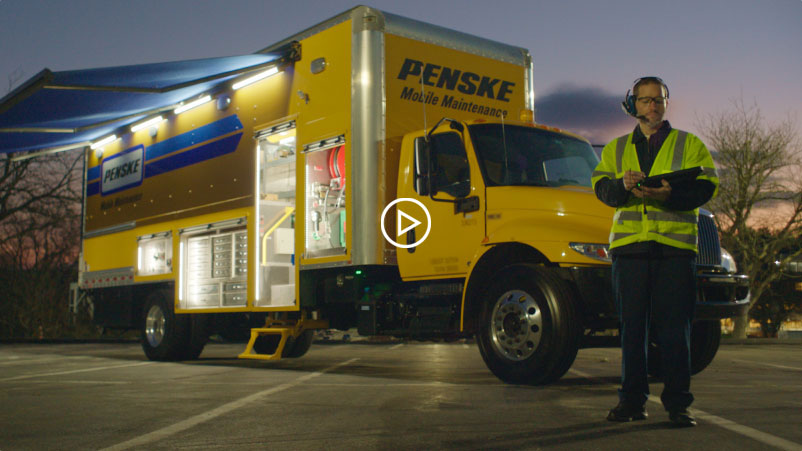 Worker stands in front of Penske Mobile Maintenance truck